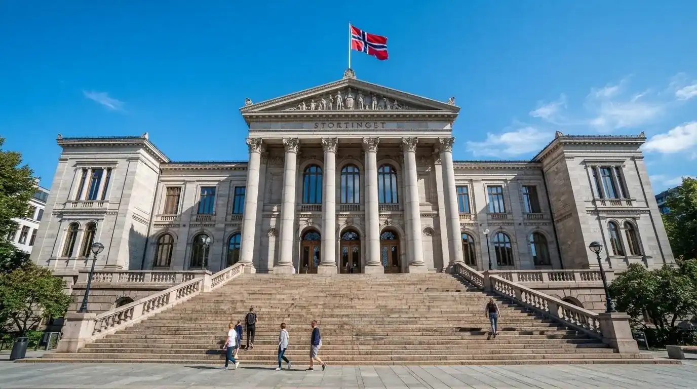 Fasade av en stor offentlig bygning i Oslo med brede trapper og et norsk flagg i vinden under klar himmel